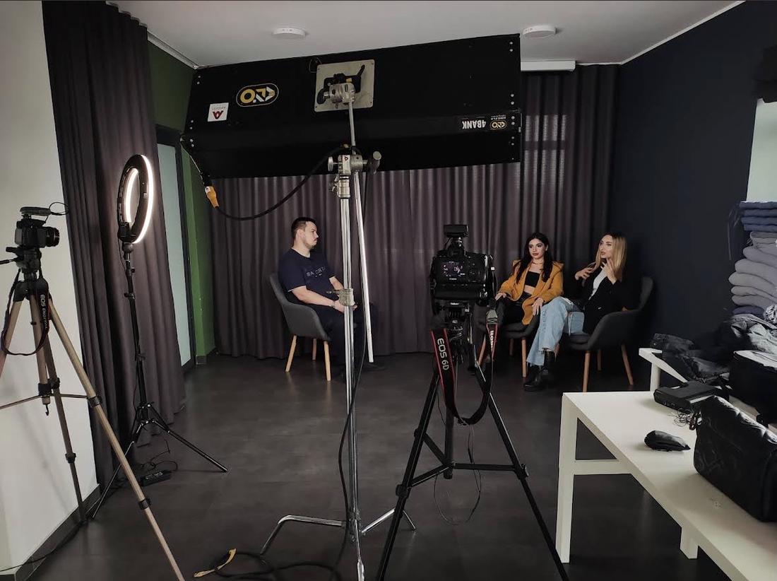 Знімальна група з камерами й світлом знімає інтерв'ю в приміщенні